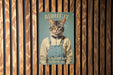 a picture of a cat wearing overalls on a wooden wall