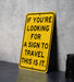 a yellow sign that says if you're looking for a sign to travel this