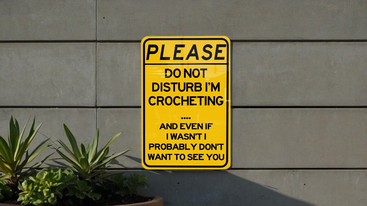 a yellow sign that says please don't disturb i'm crocheting