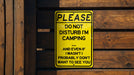 a yellow sign that is on a wooden fence