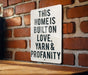 a sign on a brick wall that says this home is built on love, yarn