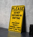 a yellow sign that says please don't disturb i'm knitting and even