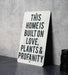 a sign that says this home is built on love plants and propanety