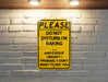 a yellow sign on a brick wall that says please don't disturb im baking