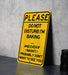 a yellow sign that says please don't disturb i'm baking and even