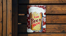 a can of cold beer hanging on a wooden wall