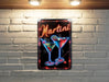 a neon martini sign on a brick wall