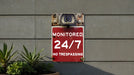 a red sign that reads monitored 24 / 7 / 17 no trespassing
