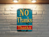 a no thanks sign on a brick wall