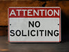 a red and white sign that says attention no solicing