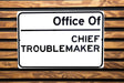 a street sign on a wooden bench that says, don beware of chief office