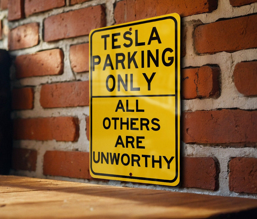 a yellow sign on a brick wall that says tesla parking only all others are un