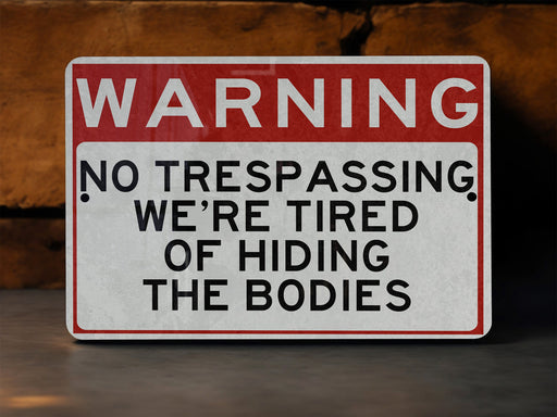 a red and white warning sign stating no trespassing