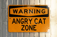 a yellow sign on a white wall that says zone