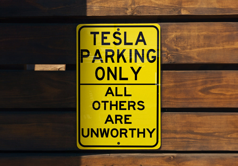 a yellow sign that says tesla parking only all others are unworthyly