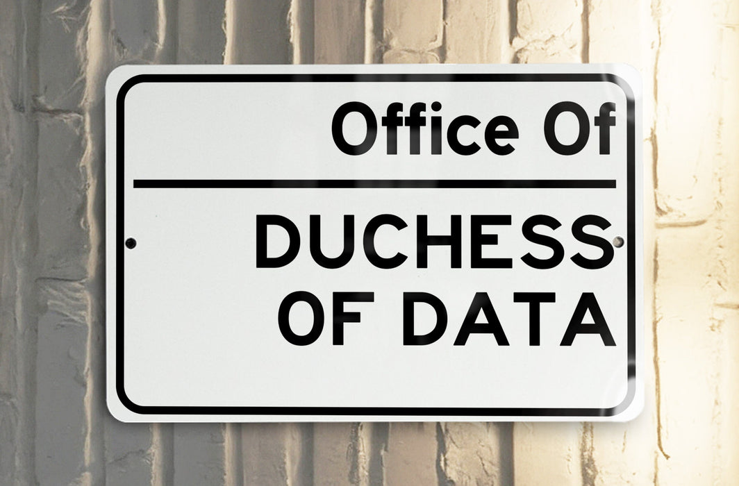 a white and black street sign on a pole