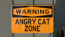 a yellow street sign on a wooden fence