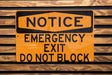 a do not block exit sign on a wooden wall