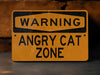 a yellow warning sign stating that an angry cat is zone