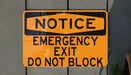 a do not block exit sign hanging on a wall