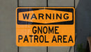 a yellow and black street sign on a wall