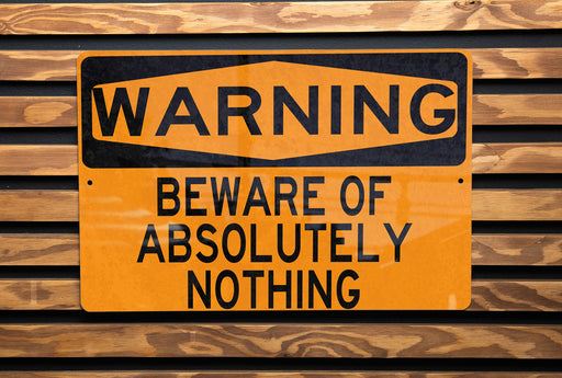a yellow and black warning sign on a wooden wall