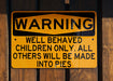 a yellow and black sign on a wooden fence