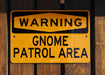 a yellow and black sign on a wooden fence