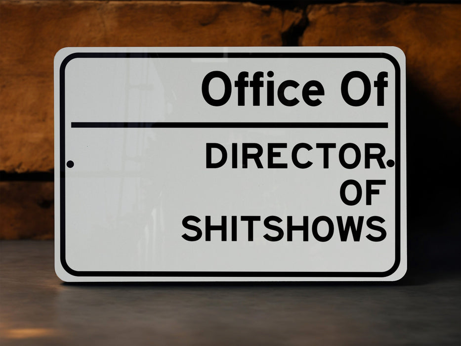 a white sign that says office of director of shitshows