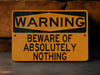 a warning sign on the ground warning of beware of absolutely nothing