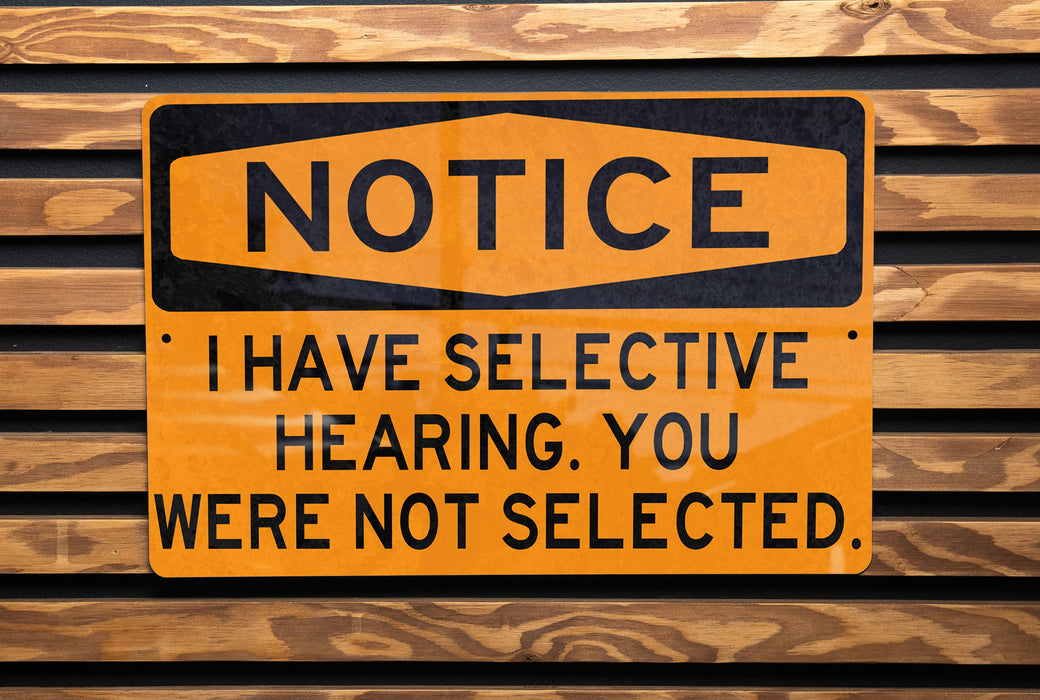 a yellow and black sign on a wooden wall