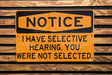 a yellow and black sign on a wooden wall