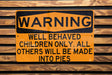 a yellow and black sign on a wooden wall