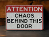 a red and white sign that says attention chaos behind this door