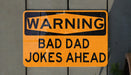 a yellow and black street sign on a wall