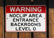 a red and white sign on a wooden fence