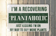 a green and white sign that says i'm a recovering plantaholic