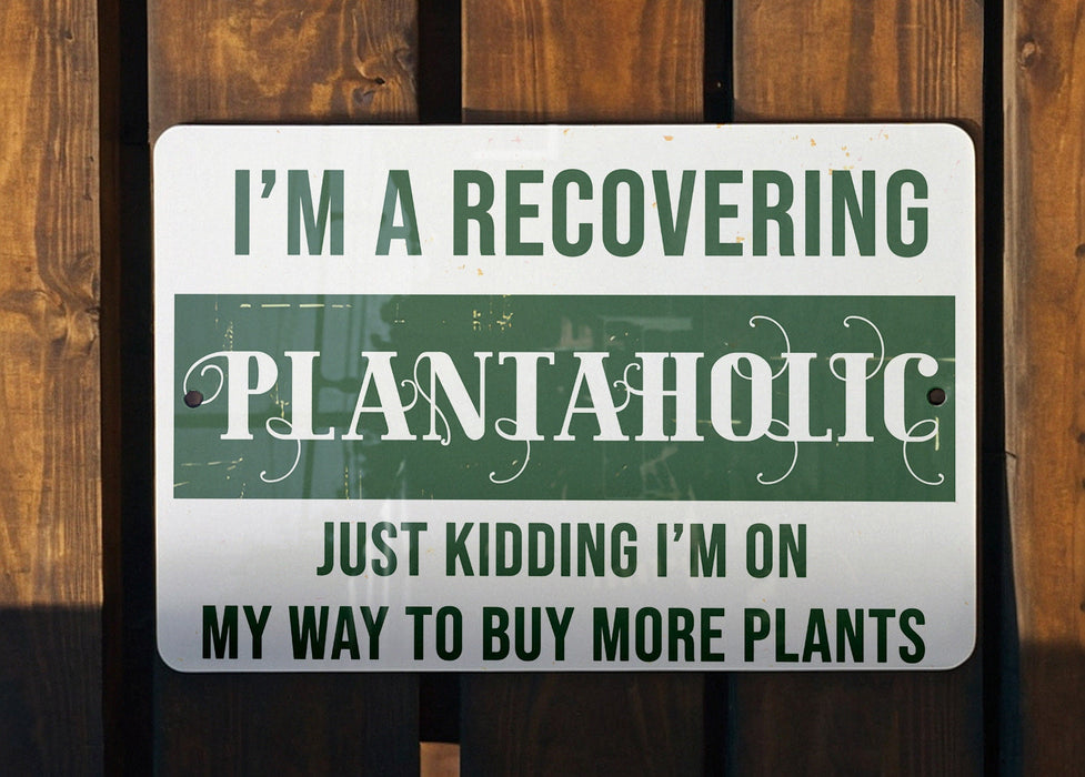 a green and white sign that says i'm a recovering plantaholic