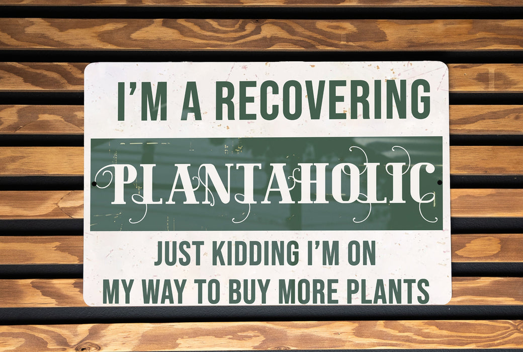 a sign on a wooden bench that says i'm a recovering plantaholic