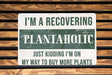 a sign on a wooden bench that says i'm a recovering plantaholic