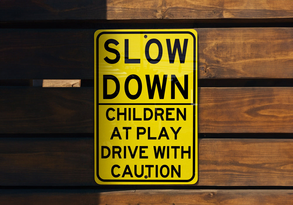 a yellow slow down sign on a wooden wall
