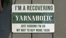 a green and white sign that says i'm a recovering yarnaholic