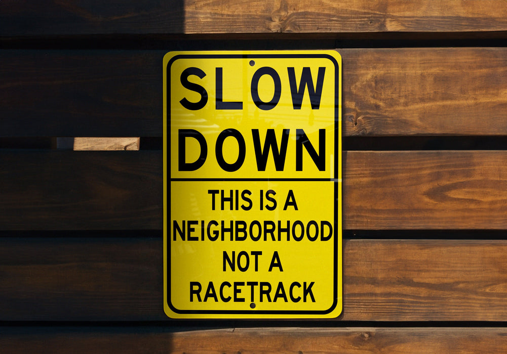 a yellow slow down sign on a wooden wall