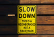 a yellow slow down sign on a wooden wall