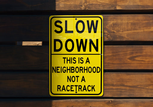 a yellow slow down sign on a wooden wall
