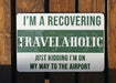 a green and white sign that says i'm a recovering travelaholic