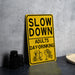 a yellow slow down sign sitting on top of a table