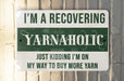 a green and white sign that says i'm a recovering yarnaholic