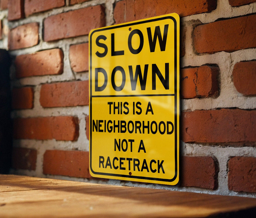 a yellow slow down sign on a brick wall