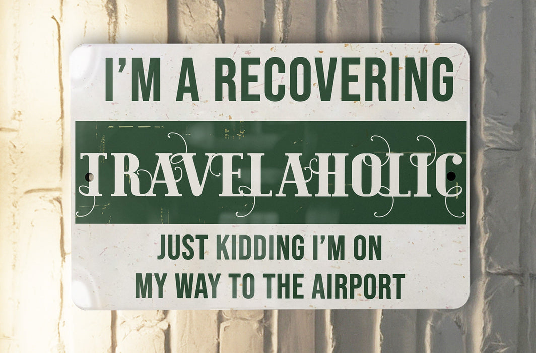 a green and white sign that says i'm a recovering travelaholic
